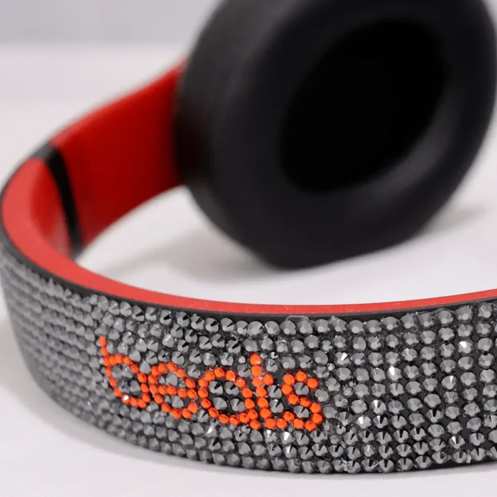Swarovski Beats Studio Pro crystal work, shown on an earlier Beats Studio model: headband set with dark crystals and the beats wordmark in red crystals