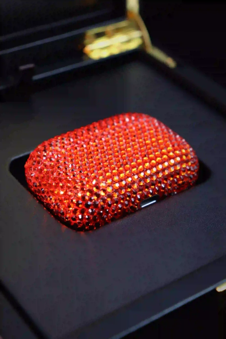 AirPods case covered in red Swarovski crystals inside a black box