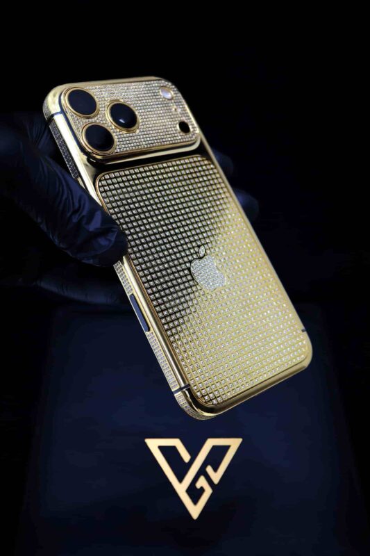 GoldPrivé 24K gold iPhone with diamond-set detailing held in a gloved hand