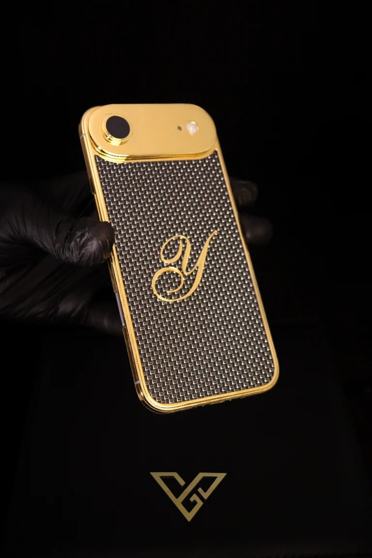 Gold iPhone Air with monogram back held in a gloved hand
